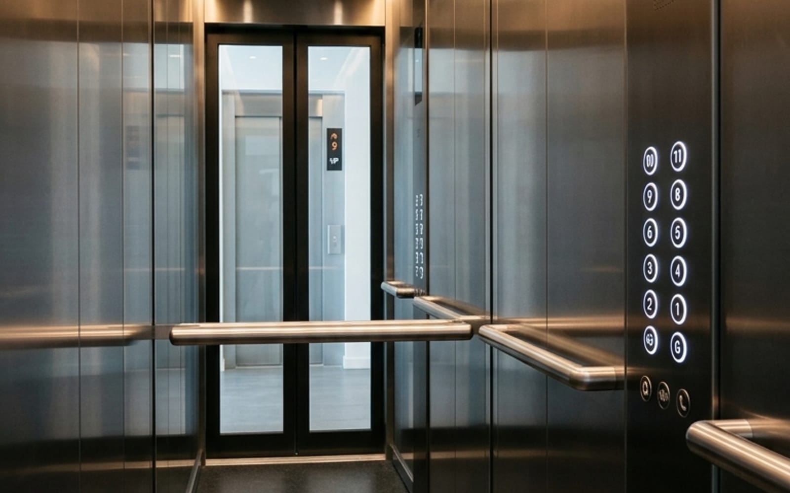 Brushed-steel passenger elevator car interior with control panel